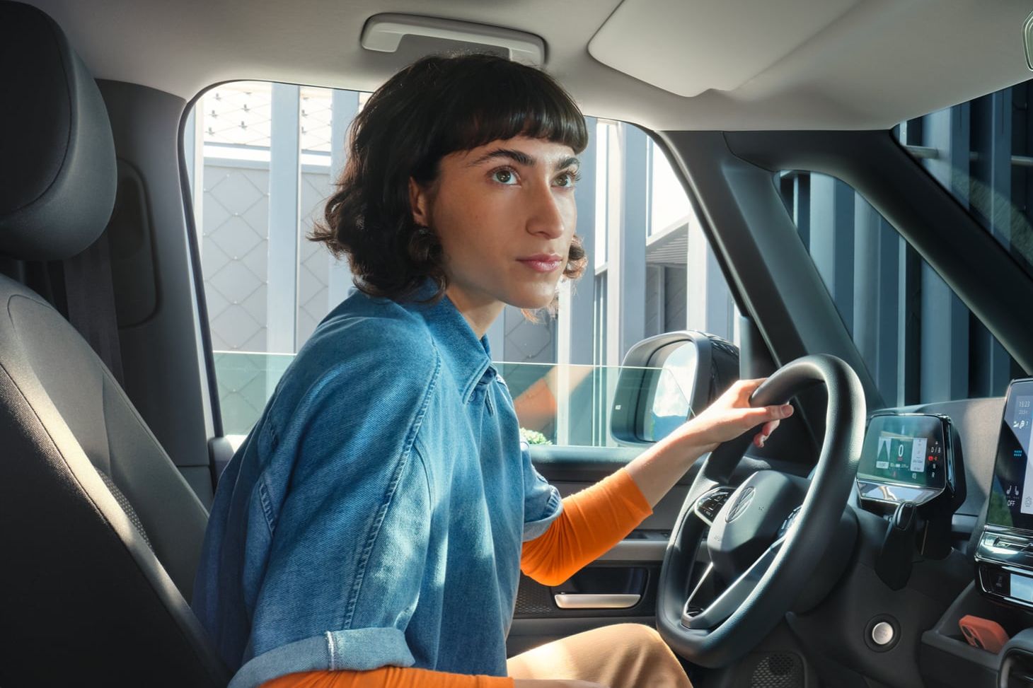 Frau steuert einen ID. Buzz, Aufnahme aus der Fahrerkabine