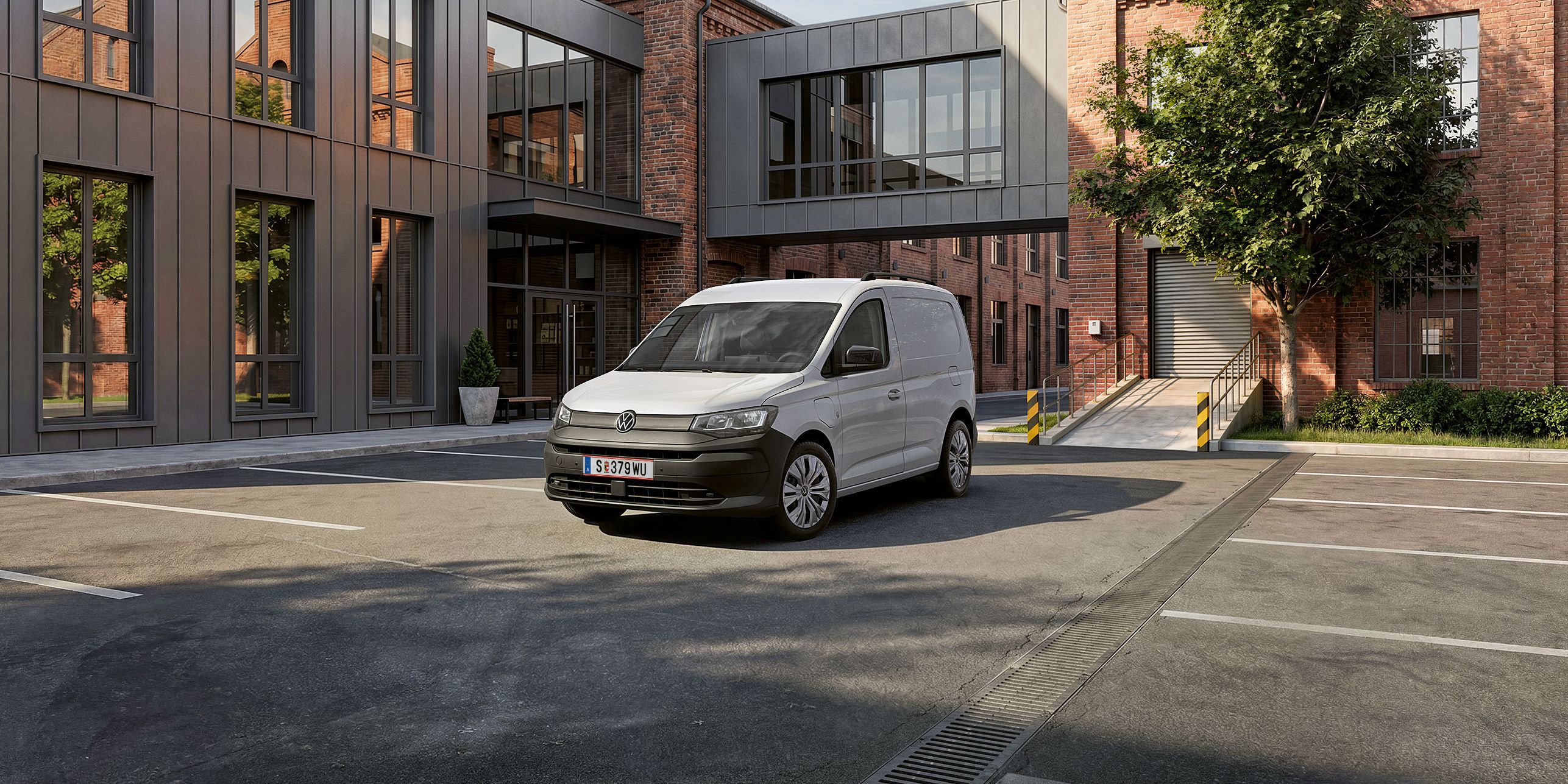 Biely Caddy Cargo stojí pre verejnou budovou.