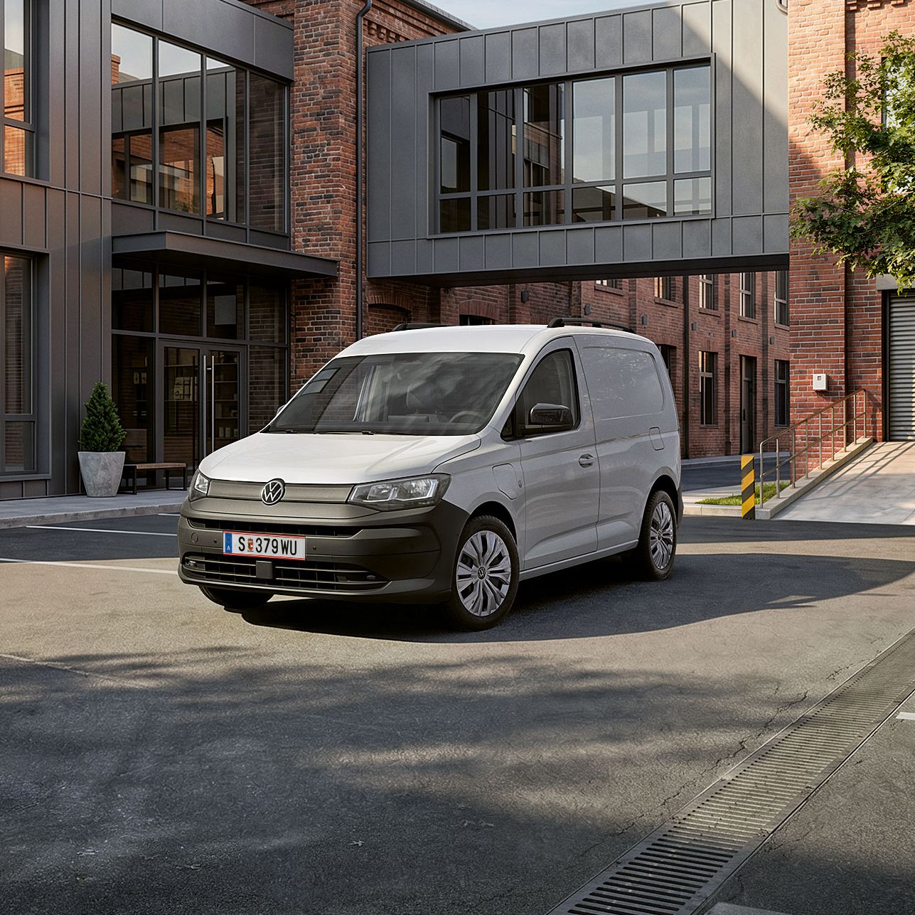 Biely Caddy Cargo stojí pre verejnou budovou.