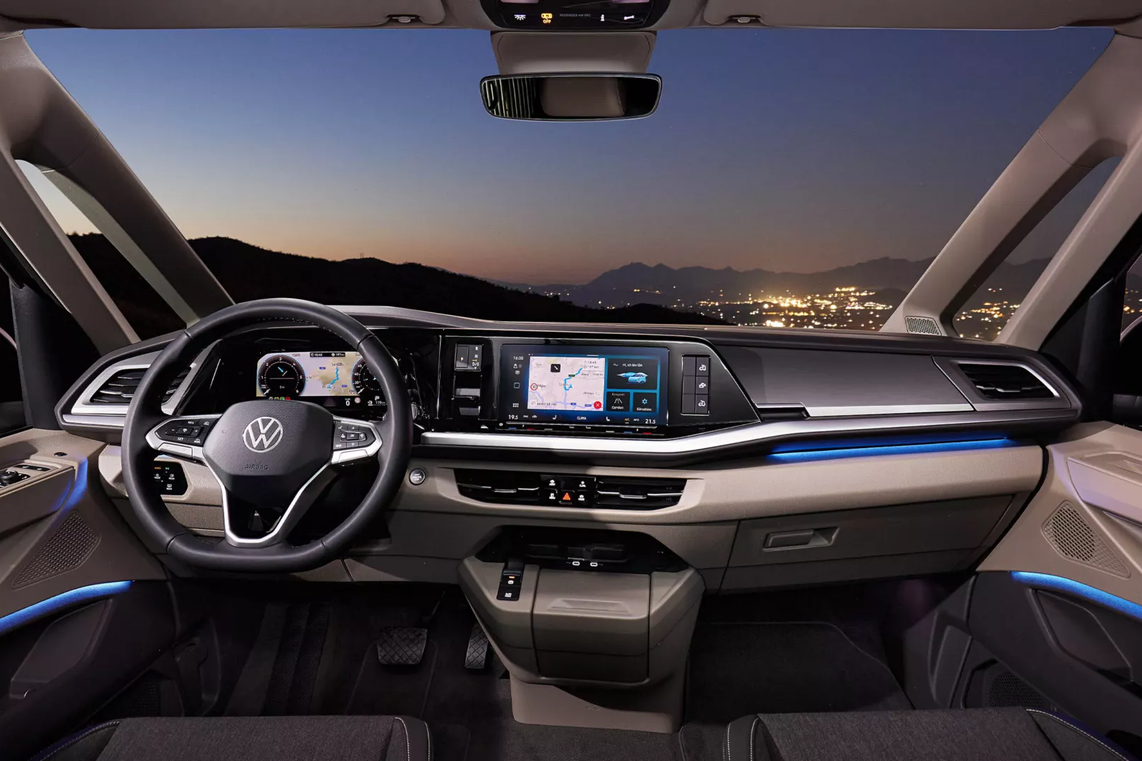 Kabína vodiča nového modelu California. Cez čelné sklo je výhľad na nočné mesto a hory v pozadí počas súmraku.