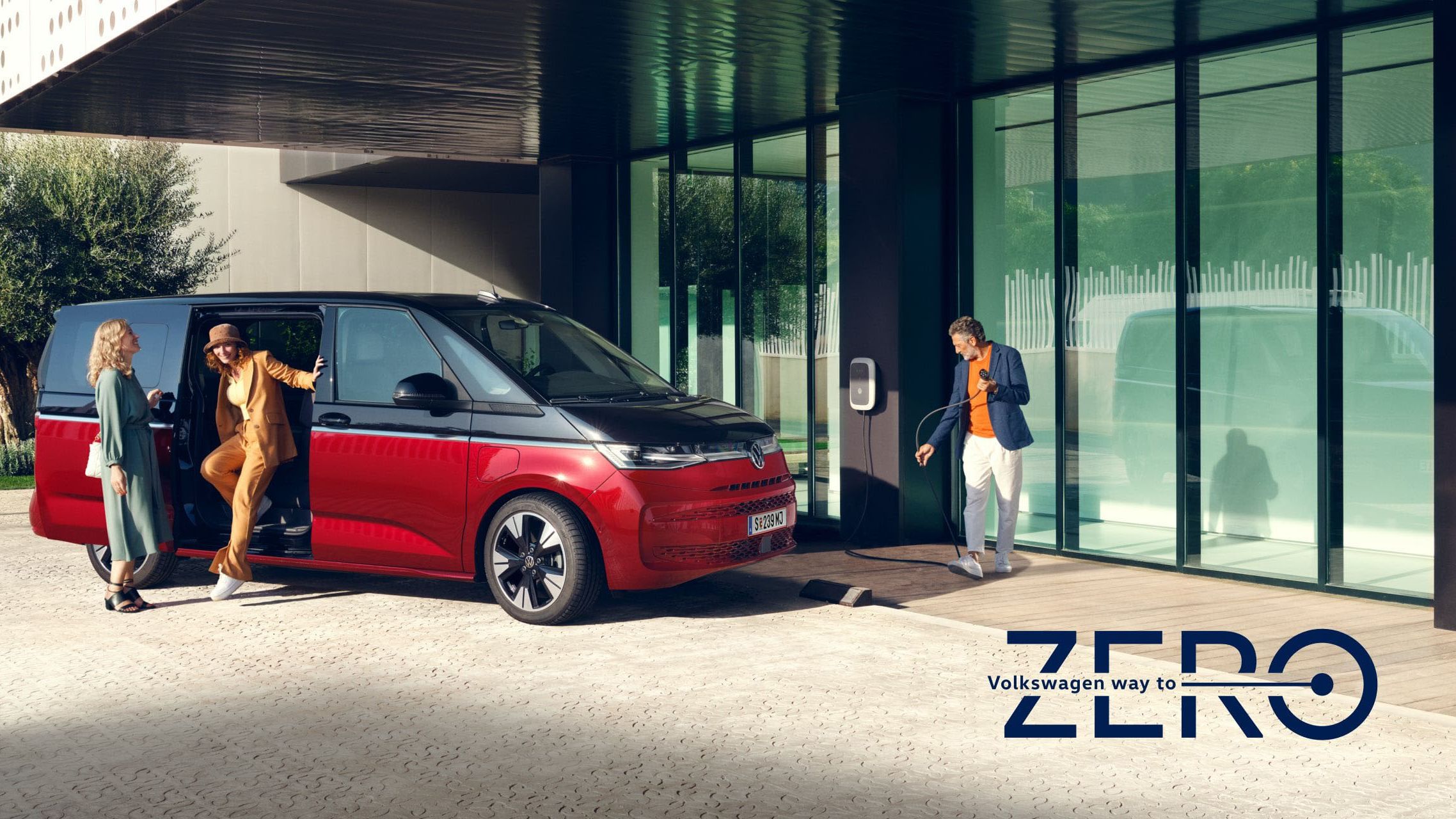 Zwei Frauen und ein Mann stehen neben dem neuen VW Multivan T7 Style 2021.