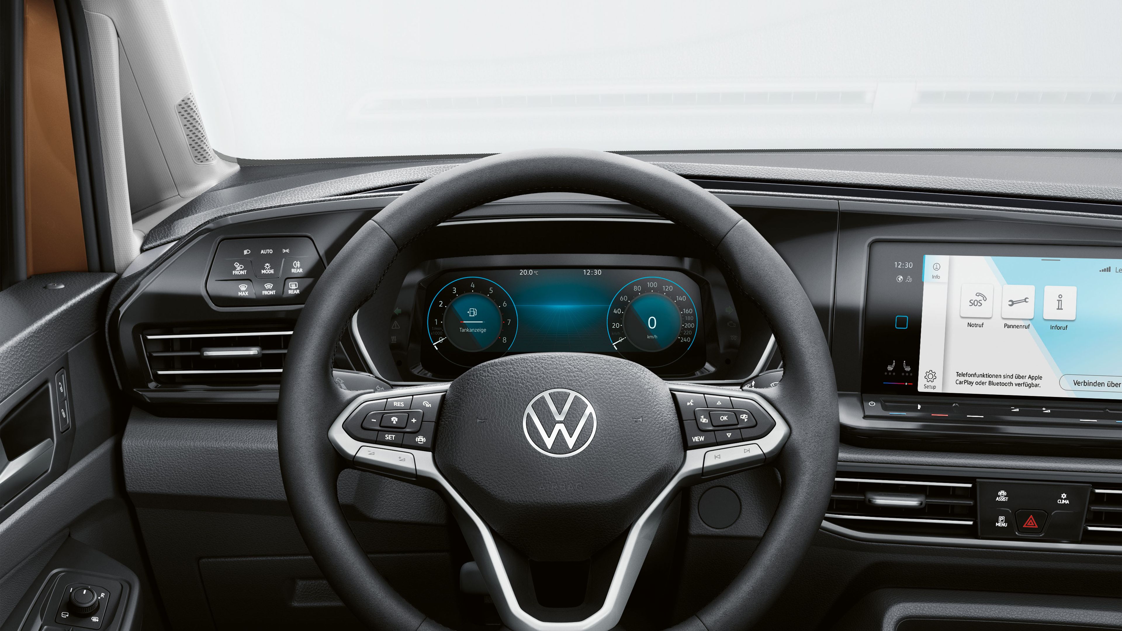 Detailný pohľad na multifunkčný volant a palubnú dosku nového automobilu Volkswagen. Na obrazovkách sú viditeľné digitálne ukazovatele a navigácia. Možnosti ovládania a tlačidlá sú umiestnené na volante, prístrojovej doske a paneli dverí.
