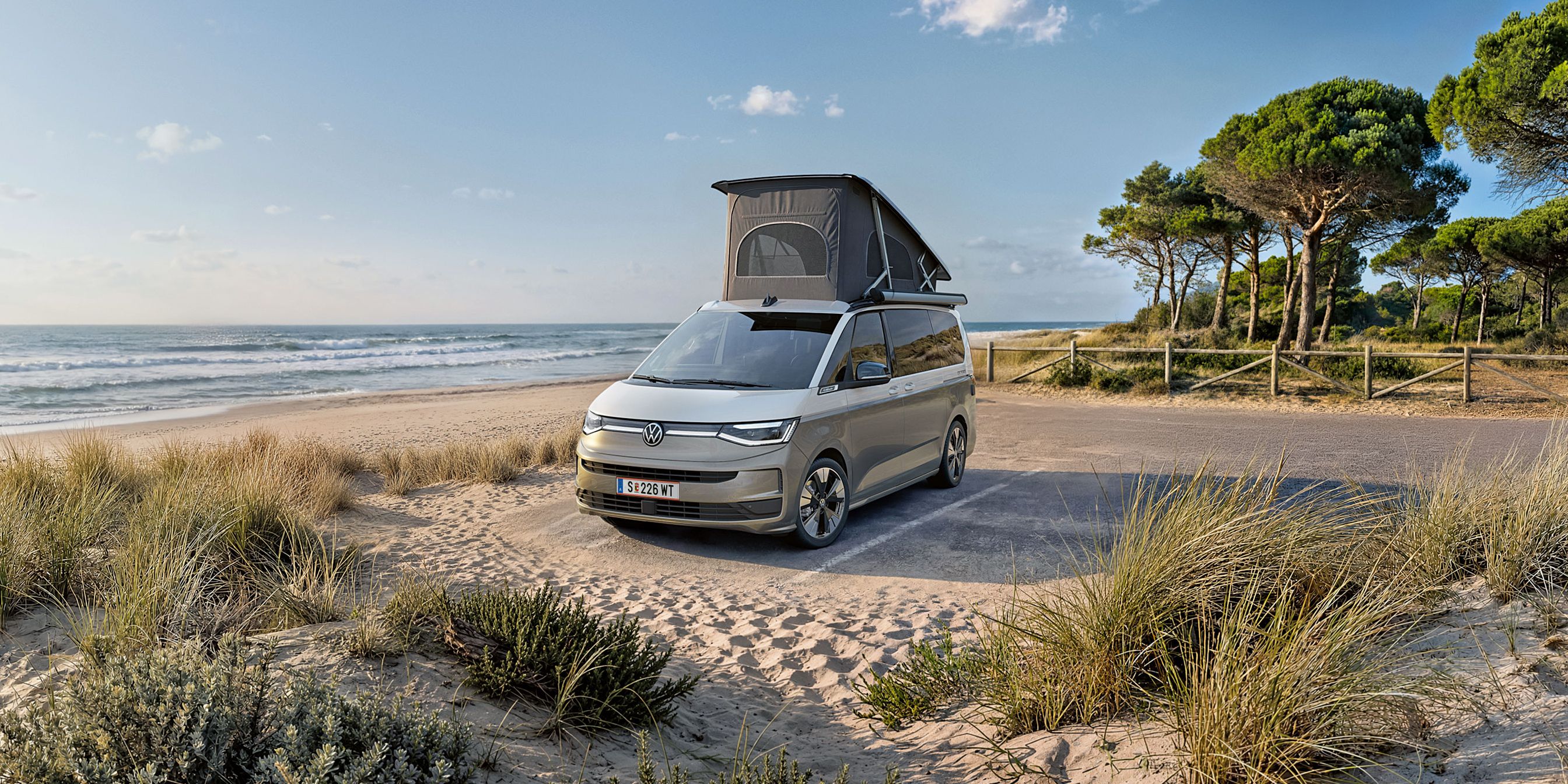 Nový VW California 2026 je zaparkovaný na pláži pri mori.