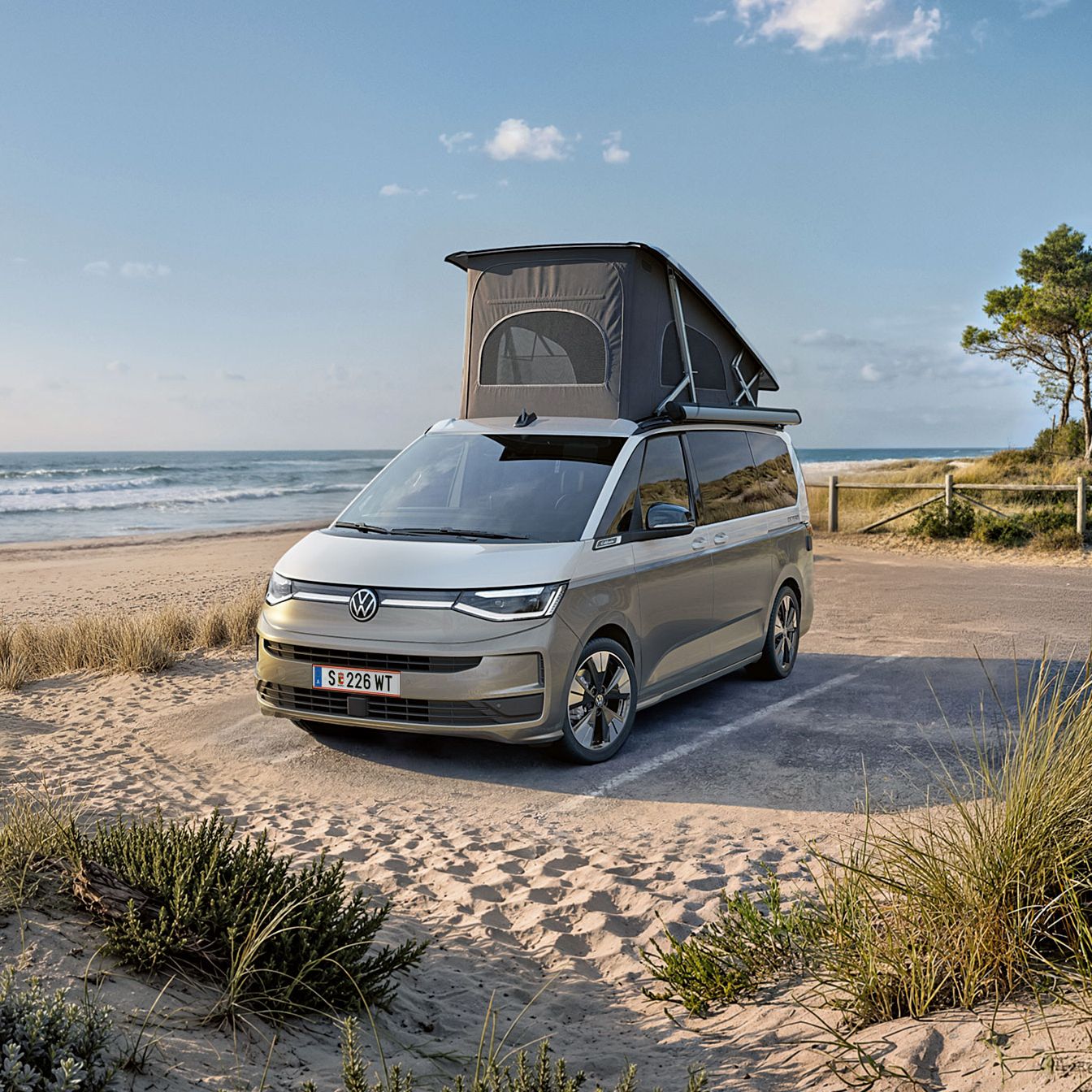 Nový VW California 2026 je zaparkovaný na pláži pri mori.